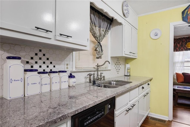 kitchen featuring dishwasher, sink, white cabinets, and light stone counters