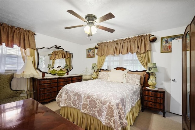 bedroom with ceiling fan and light colored carpet