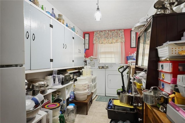 kitchen with pendant lighting, white cabinets, independent washer and dryer, and light tile patterned floors