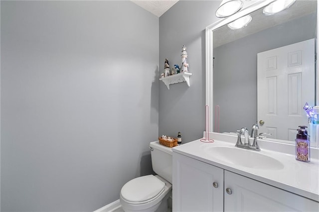 bathroom featuring baseboards, vanity, and toilet