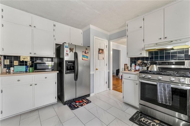 kitchen with stainless steel appliances, light countertops, decorative backsplash, white cabinets, and under cabinet range hood