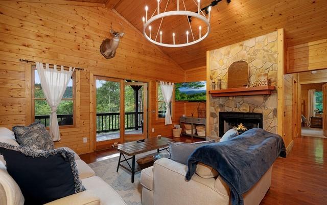 living room with wooden walls, beamed ceiling, a fireplace, and hardwood / wood-style floors