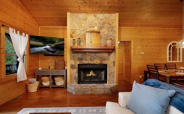 living room featuring wood walls, a fireplace, vaulted ceiling, and hardwood / wood-style floors