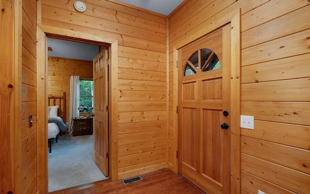 entryway featuring hardwood / wood-style flooring and wooden walls