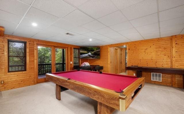 game room featuring a drop ceiling, wood walls, and billiards