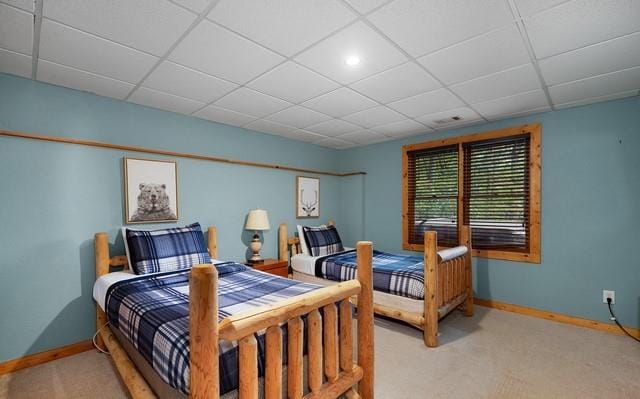 carpeted bedroom with a paneled ceiling