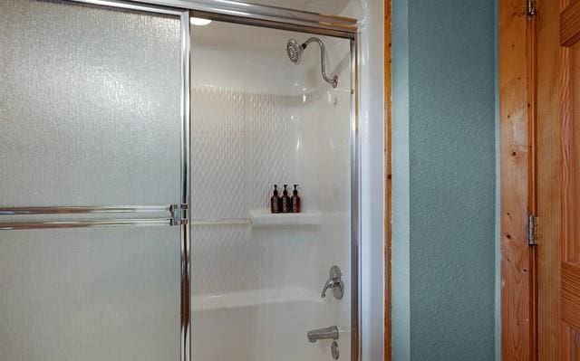 bathroom with combined bath / shower with glass door