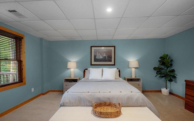 carpeted bedroom with a drop ceiling