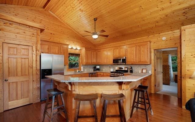 kitchen with wood-type flooring, stainless steel appliances, wood walls, and wooden ceiling