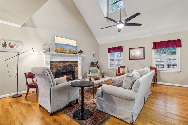 living room featuring light wood-type flooring, a fireplace, and a healthy amount of sunlight