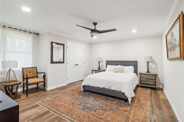 bedroom with light hardwood / wood-style floors, ceiling fan, and ornamental molding