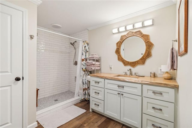 bathroom featuring a shower with curtain, vanity, hardwood / wood-style flooring, and ornamental molding