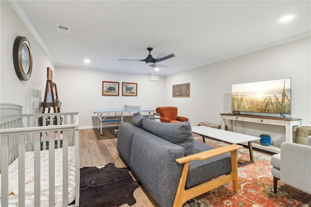 living room with ceiling fan, wood-type flooring, and crown molding