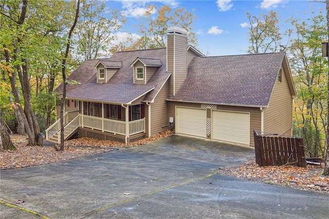 new england style home featuring a garage and covered porch