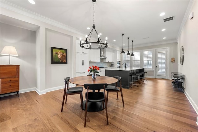 dining room featuring baseboards, visible vents, light wood-style flooring, recessed lighting, and ornamental molding