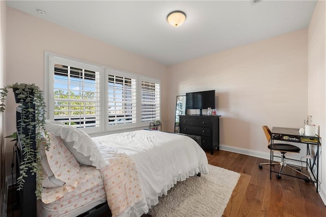 bedroom with baseboards and wood-type flooring