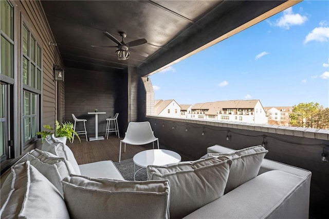 balcony with outdoor lounge area, a ceiling fan, a residential view, and a sunroom