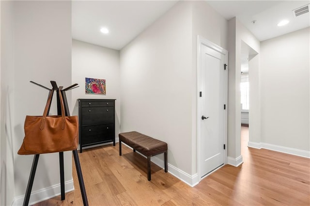 hallway featuring recessed lighting, visible vents, baseboards, and light wood finished floors