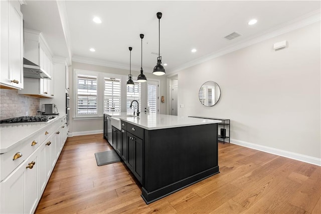 kitchen featuring stainless steel gas cooktop, visible vents, white cabinets, and light countertops