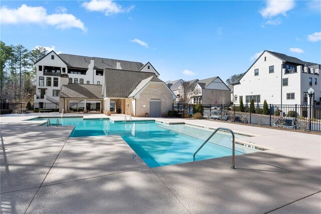 pool featuring a patio area, fence, and a residential view