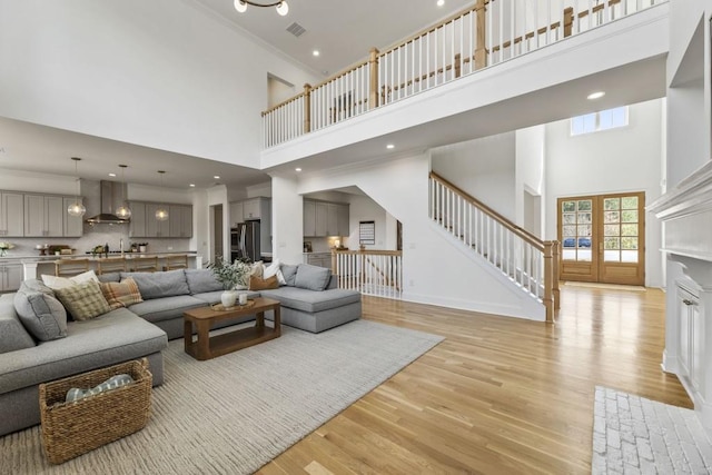 828 Chestnut Pl, Milton, GA 30004 - living room featuring a towering ceiling, light wood finished floors, stairway, ornamental molding, and baseboards