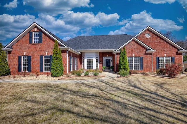 view of front of home featuring brick siding and a front lawn