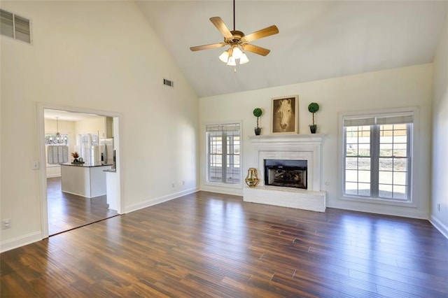 unfurnished living room with visible vents, a fireplace with raised hearth, and plenty of natural light