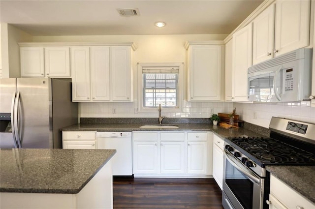 kitchen with visible vents, backsplash, white cabinets, stainless steel appliances, and a sink