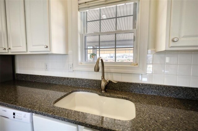 kitchen with white cabinets, white dishwasher, backsplash, and a sink
