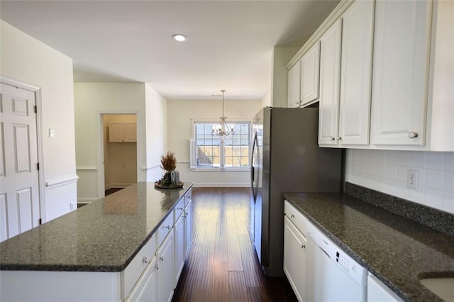 kitchen featuring white dishwasher, decorative backsplash, white cabinetry, a notable chandelier, and a center island