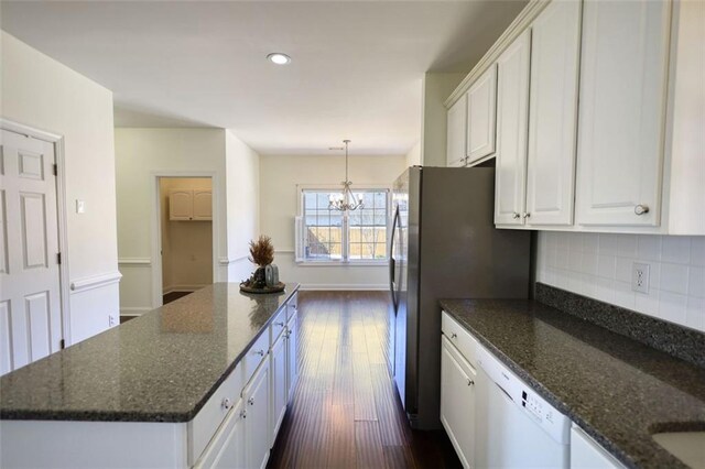 kitchen with a center island, white dishwasher, decorative backsplash, white cabinets, and a chandelier