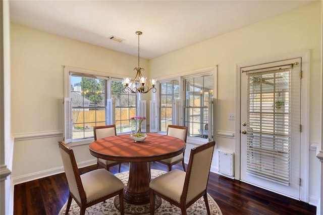 dining area with a notable chandelier, dark wood-style floors, visible vents, and baseboards