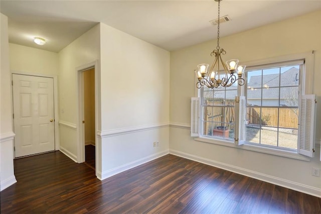 unfurnished dining area featuring visible vents, a healthy amount of sunlight, an inviting chandelier, and dark wood-style flooring