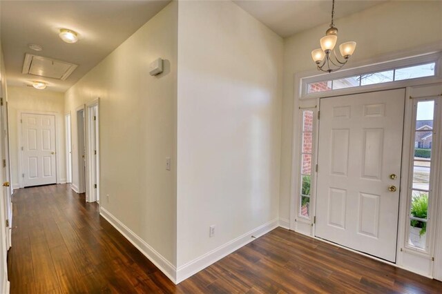 entryway featuring dark wood-type flooring, baseboards, and a chandelier