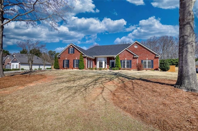 view of front of home with a front lawn and brick siding