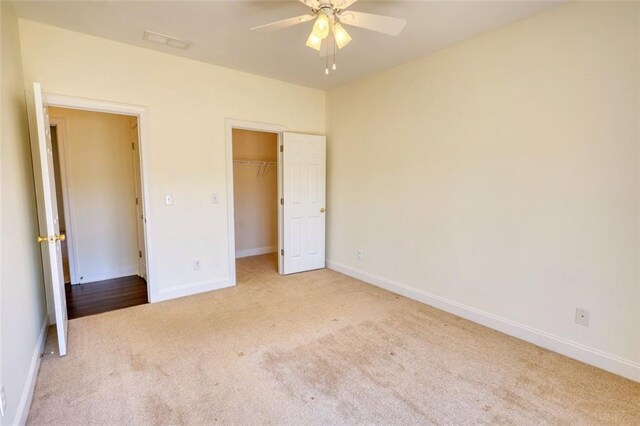 unfurnished bedroom featuring carpet flooring, visible vents, baseboards, and ceiling fan