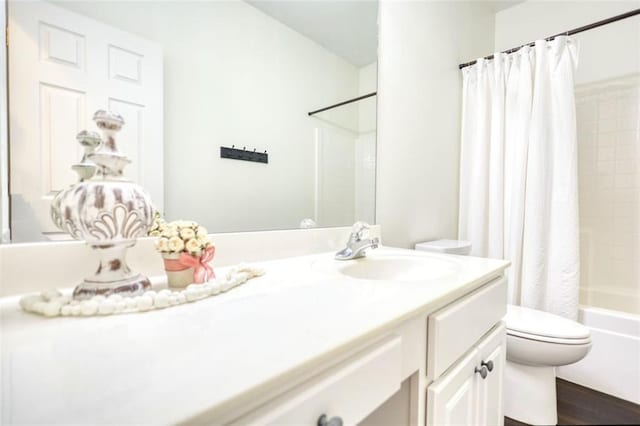 bathroom featuring vanity, shower / tub combo, and toilet