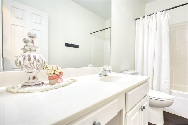 bathroom featuring toilet, vanity, and shower / bath combo