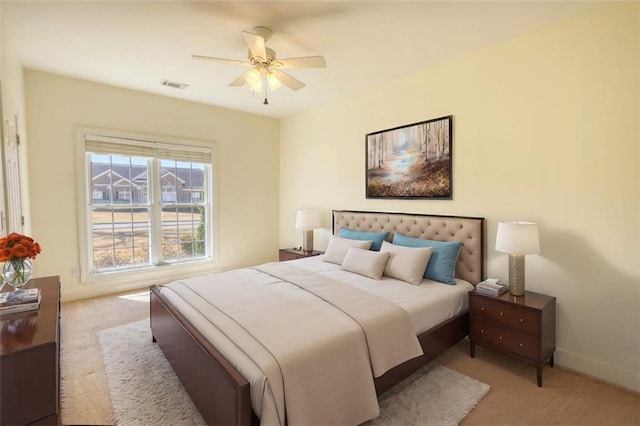 carpeted bedroom featuring baseboards, visible vents, and ceiling fan