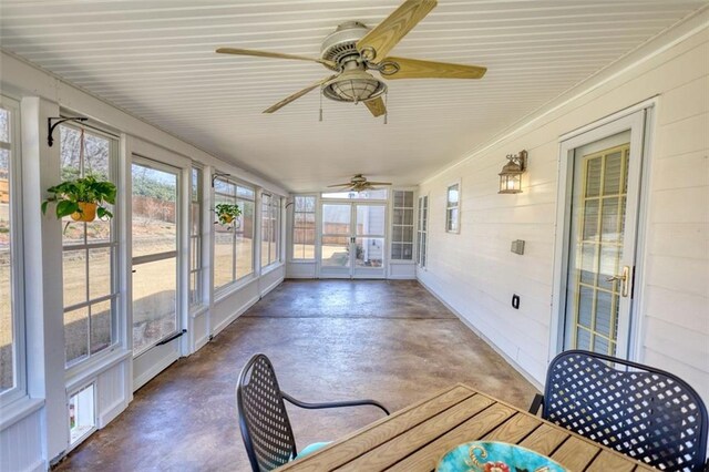unfurnished sunroom featuring ceiling fan