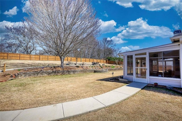 view of yard with a fenced backyard and a sunroom