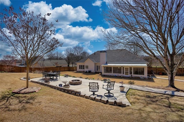 rear view of property with a patio, a fire pit, a lawn, and a fenced backyard