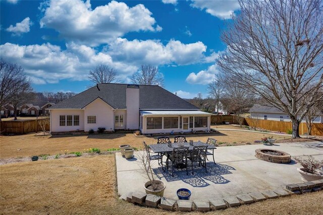 back of house featuring a patio, a fire pit, a fenced backyard, and a lawn