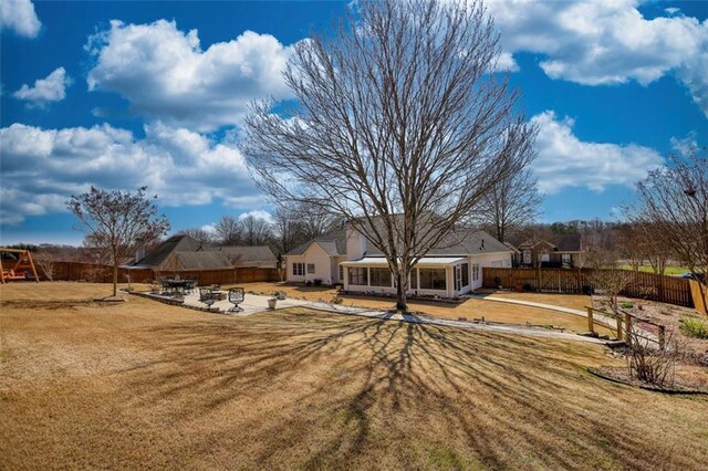 view of yard with a patio area, a fire pit, a playground, and fence
