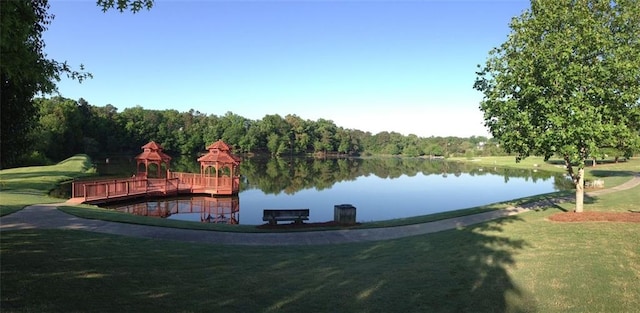 exterior space featuring a gazebo, a water view, and a lawn