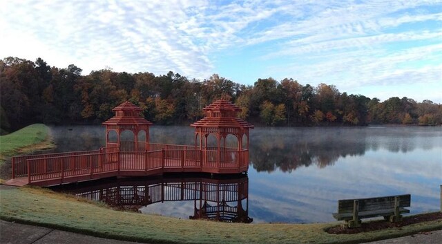 dock area featuring a gazebo, a forest view, and a water view