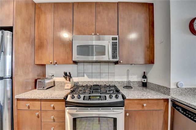 kitchen featuring light stone countertops and appliances with stainless steel finishes