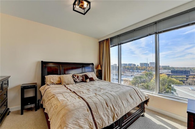 bedroom with light colored carpet and multiple windows