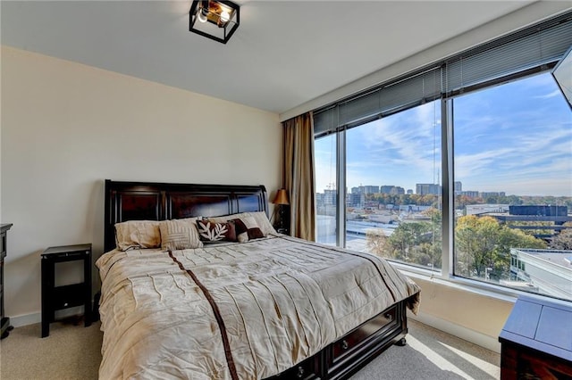 bedroom featuring light colored carpet and multiple windows