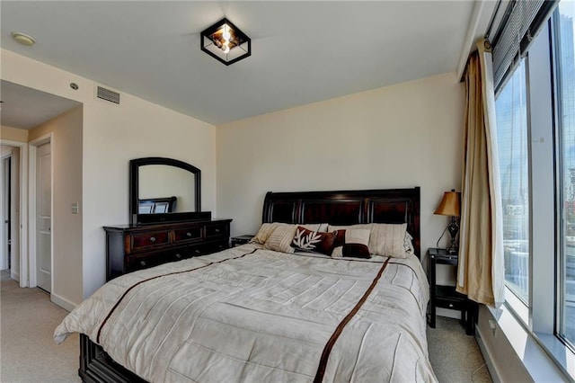 bedroom with light carpet and multiple windows